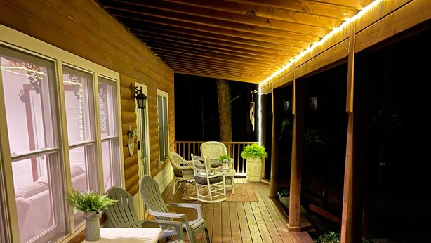 Eine Holzterrasse mit Sitzgelegenheiten im Freien und einem überdachten Bereich.
