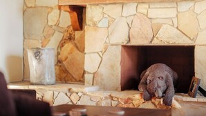 A stone fireplace with a bear figurine and a television above it. - Lake O' The Pines Lake Front
Two Bedroom Home - A Slice of Paradise (Jefferson)