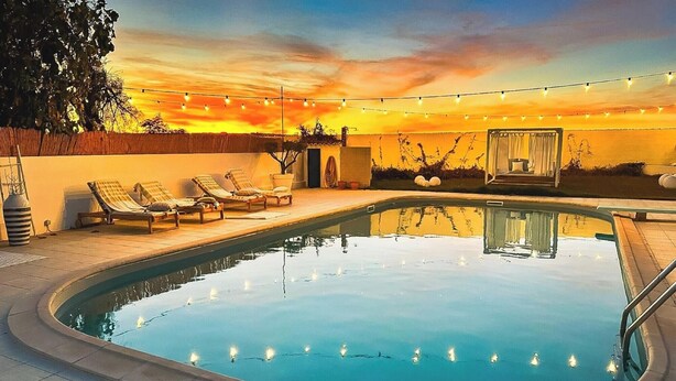 A swimming pool with lounge chairs and string lights. - Cottage 'Olive Village Alentejo' with Private Pool, Wi-Fi and Air Conditioning (Vila Azedo)