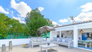 An outdoor patio with two white sofas, a coffee table, and a large umbrella. - Cottage 'Olive Village Alentejo' with Private Pool, Wi-Fi and Air Conditioning (Vila Azedo)
