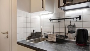 Eine Küche mit Spüle, Wasserkocher und einer Wandhalterung.