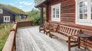 A wooden cabin with a porch, wooden benches, and a small table. - 2 bedroom lovely home in Oppdal (Oppdal)
