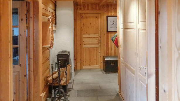 A narrow hallway with wooden walls and doors, a small heater, and a storage chest. - 2 bedroom lovely home in Oppdal (Oppdal)