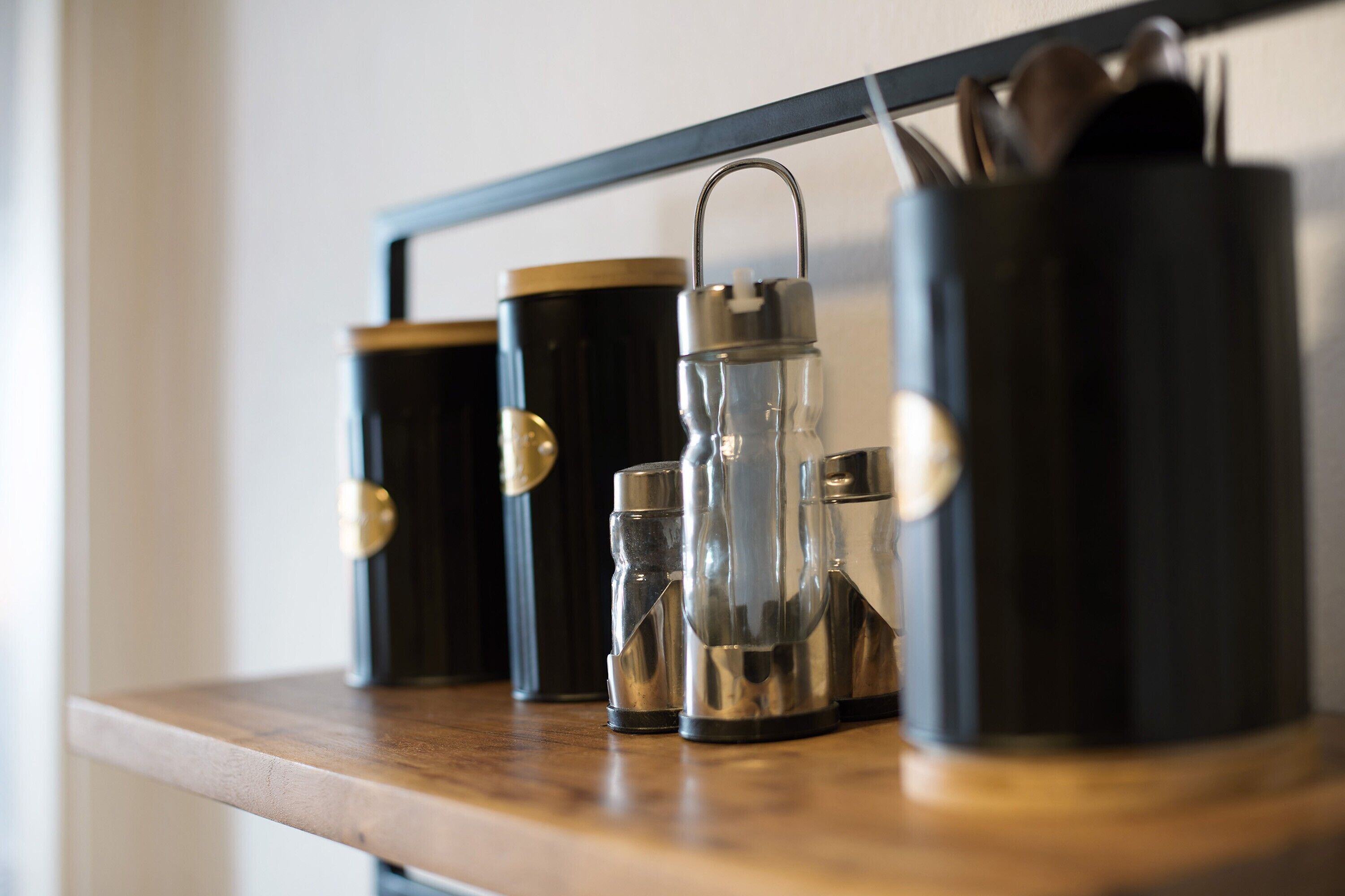 A shelf with three containers and a water bottle.