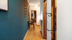 A hallway with a wooden floor, a dining area with a table and chairs, and a door with a black handle. - Holiday Apartment 'Am Bahnhof Freiburg' with Wi-Fi (Freiburg im Breisgau)