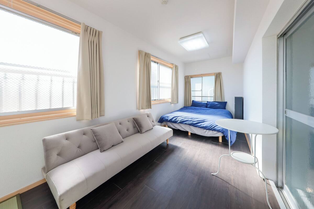 A modern bedroom with a bed, a sofa, and a small table.