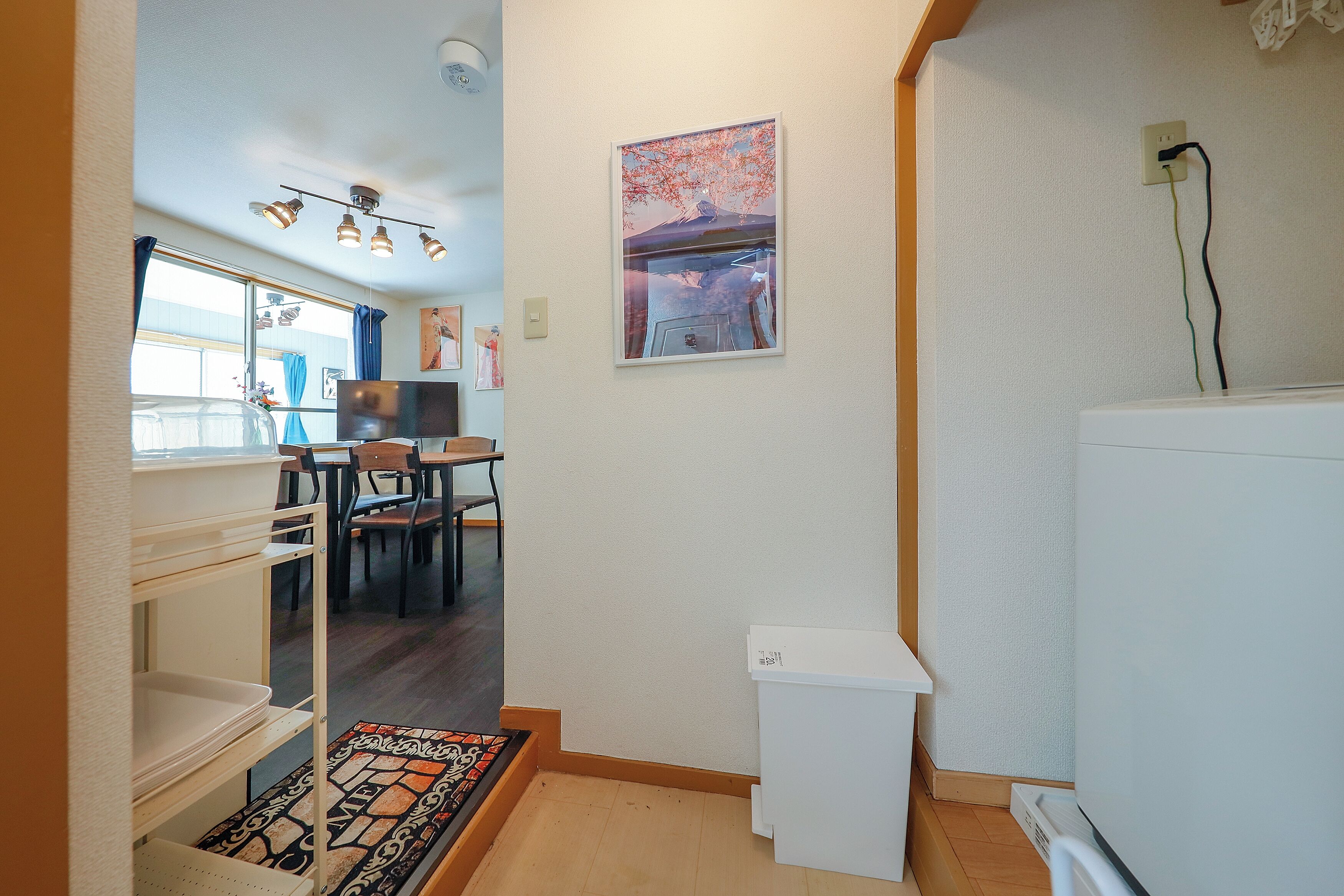 Une cuisine compacte comprenant un réfrigérateur, un coin repas avec des chaises et une petite table.