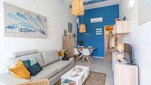 Un salon moderne avec un canapé, une table basse et un coin repas comprenant des chaises et une table.
