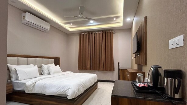 Ein Hotelzimmer mit Bett, Schreibtisch und Kaffeemaschine sowie einer Klimaanlage.