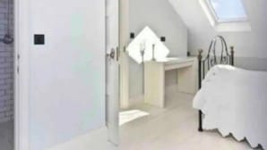 A bedroom with a skylight, a bed, and a bathroom with a sink and mirror. - Shepherds Bush W12 Magical Townhouse nr Westfield (London)