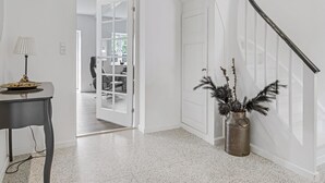 Een modern interieur met een trap, een eethoek en een hal die leidt naar een kamer met uitzicht.