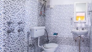 A bathroom with a toilet, sink, and shower. - Oak Land House (Manali)