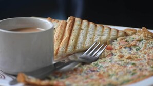A plate with a slice of toast and a cup of coffee. - Oak Land House (Manali)