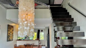 A modern interior with a staircase, dining area, and artwork. - 3bedroom Penthouse at Asiana Villas  (Boracay Island)
