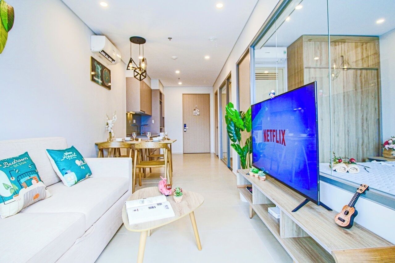 Una sala de estar moderna con sofá, mesa de centro y televisor mostrando 'NETFLIX'.