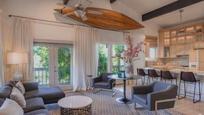 A modern living room with a sofa, chairs, a coffee table, and a dining area with a table and chairs. - The Treehouse: Spacious Retreat with Theater Room, Fire Pit & Mountain Views (Orem)