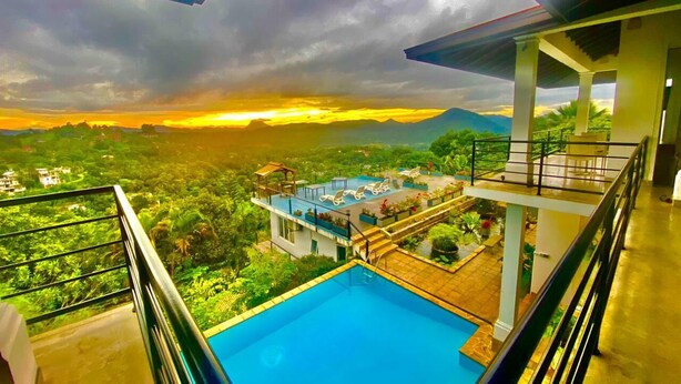A swimming pool with a view of a lush landscape and a sunset. - 390 Villa Vista (Kandy)
