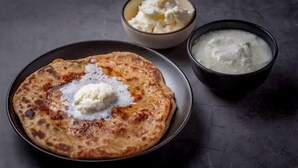 A plate with a flatbread topped with a dollop of white sauce, accompanied by two bowls of white sauce. - Rameshwaram Stay (Faizabad)