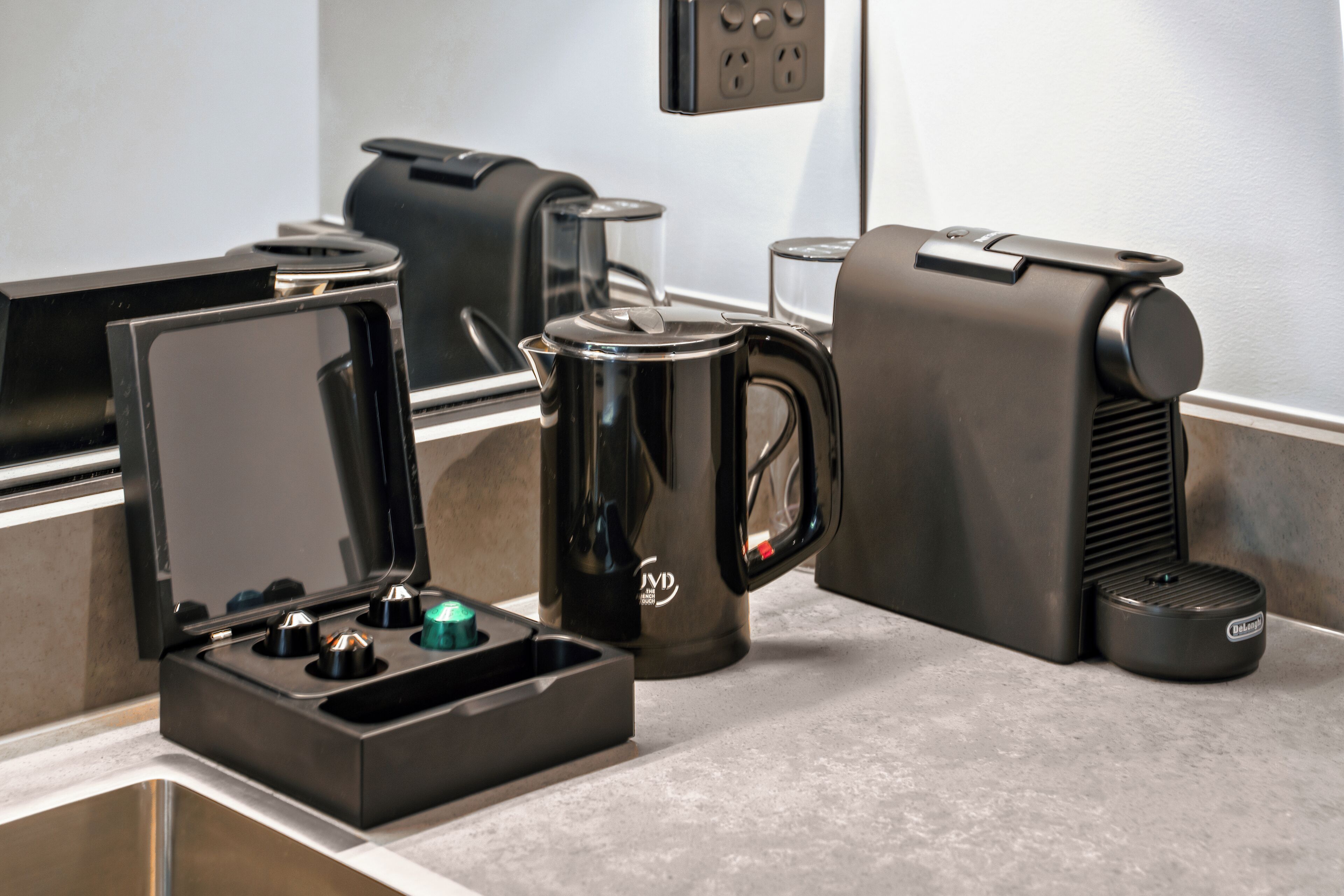 A coffee maker, a kettle, and a coffee pot on a countertop.