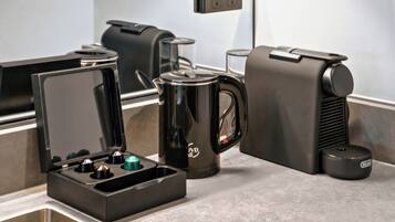 A coffee maker, a kettle, and a coffee pot on a countertop.