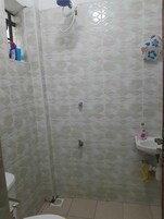 Ducha, artículos de tocador gratuitos, pantuflas, toallas