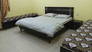 A bedroom with a bed, a bench, and a nightstand. - G G Multi Complex (Sardhana)