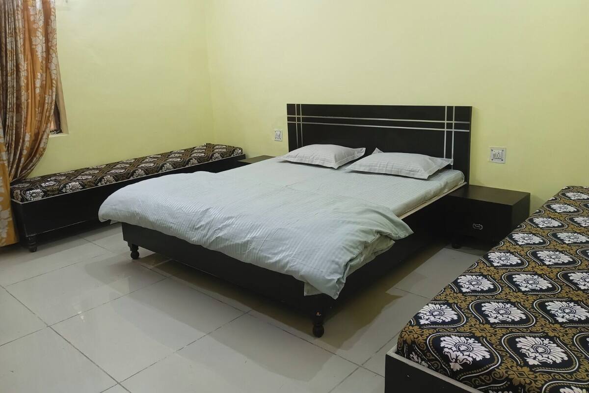 A bedroom with a bed, a bench, and a nightstand.