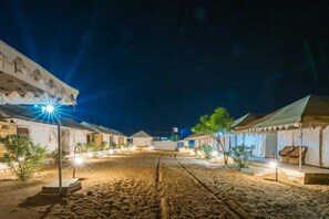 A desert-style hotel with outdoor seating and a sandy courtyard. - Robin Desert Safari Camp  (Jaisalmer)