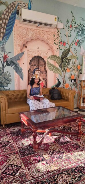 A room with a brown sofa, a glass coffee table, and a patterned carpet. - Robin Desert Safari Camp  (Jaisalmer)