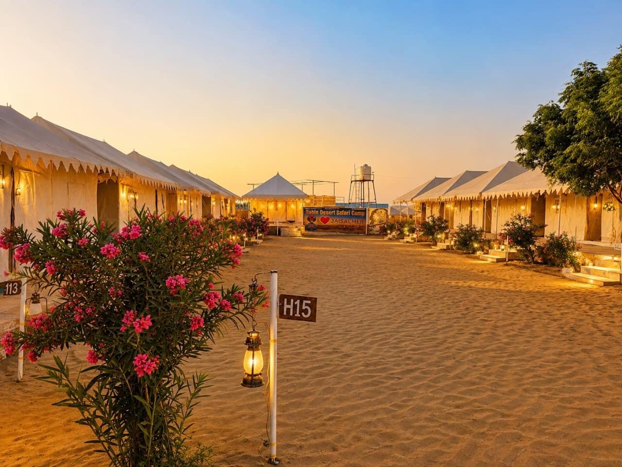 A desert camp with tents, a sign for 'Bobbi Desert Safari Camp,' and a clear sky.