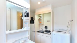 A compact kitchen with a sink, microwave, and a small refrigerator. - Le Cocon Nakarokugo by Tranova (Tokyo)