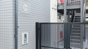 A gated entrance with a metal gate and a wall-mounted security panel. - Le Cocon Nakarokugo by Tranova (Tokyo)