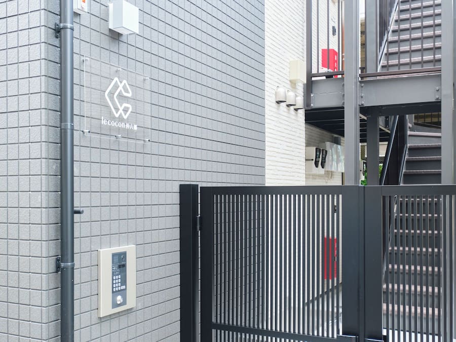 A gated entrance with a metal gate and a wall-mounted security panel.