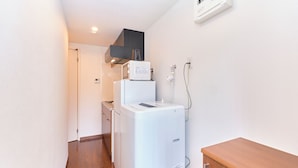 A compact kitchen with a refrigerator, microwave, and a small sink. - Le Cocon Nakarokugo by Tranova (Tokyo)
