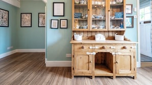 A kitchen with a wooden cabinet containing dishes and a chalkboard menu. - Beautiful 3BD Fam Retreat in Oxfordshire (Chipping Norton)