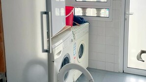 A compact laundry room with a Bosch washing machine, a dryer, and a window with a geometric pattern. - Cq15 Cozy Studio Next to HUC (Coimbra)