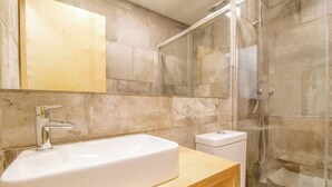 A modern bathroom with a large white sink, a glass shower enclosure, and a wooden vanity. - Cq15 Cozy Studio Next to HUC (Coimbra)