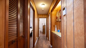 Ein Holzflur mit einer Rezeption, einer Uhr und einer Tür zu einem Zimmer.