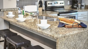 A kitchen with granite countertops, a stainless steel sink, a toaster, and a coffee maker. - Family Oasis, Cozy Retreat With Bunk Room (Kissimmee)