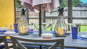 An outdoor dining area with metal tables, chairs, and a covered section with a tablecloth. - Family Oasis, Cozy Retreat With Bunk Room (Kissimmee)