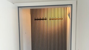 A narrow hallway with a vertical striped wall and a door at the end. - Ferienwohnung Juli - neu Renovierte, Moderne Ferienwohnung (Medebach)
