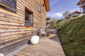 Une cabane en bois dotée d’une terrasse, de sièges extérieurs et d’une enseigne indiquant qu’il s’agit d’un centre de sports et de bien-être.