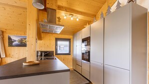 Une cuisine moderne avec des murs en bois, un grand îlot central et des appareils électroménagers intégrés.