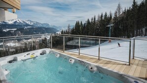 Boblebad med udsigt til et sneklædt bjerglandskab.