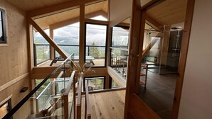 Um interior moderno com detalhes em madeira, janelas amplas e vista para o exterior.