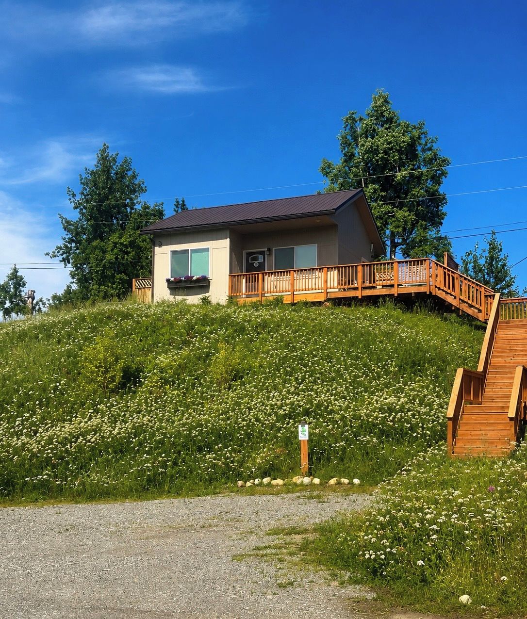 A two-story building with a wooden deck and a staircase leading to the upper level.