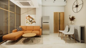A modern living room with a sofa, a round coffee table, and a TV stand. - Apartment De Thamel  (Kathmandu)