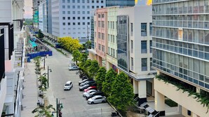 A multi-story parking structure adjacent to a modern building with a glass facade. - Hubomoto Megaworld Suites (Iloilo)