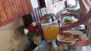 Een buffetopstelling met een fruitschaal, borden en diverse soorten eten.