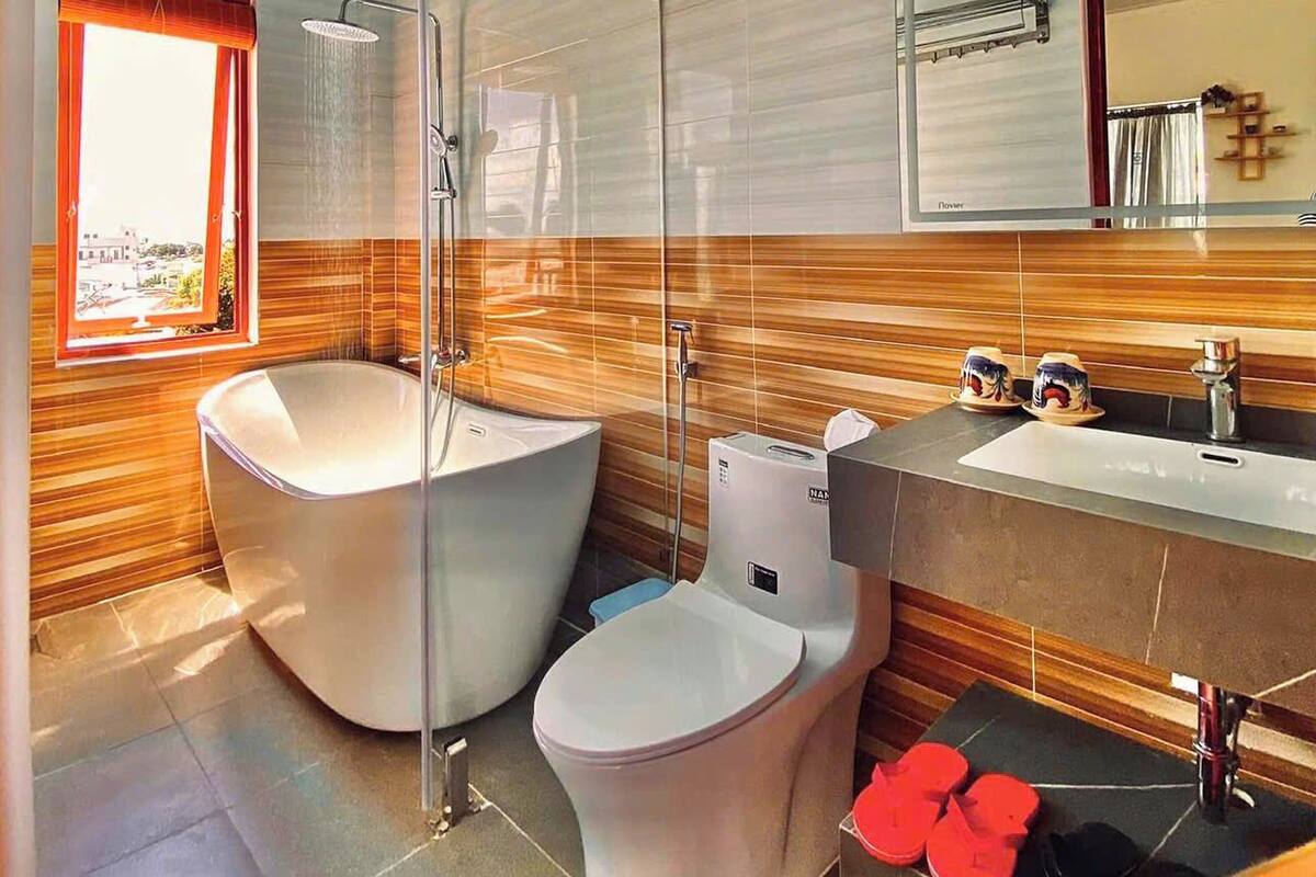 Un bagno moderno con una vasca autonoma, un water e un lavandino.